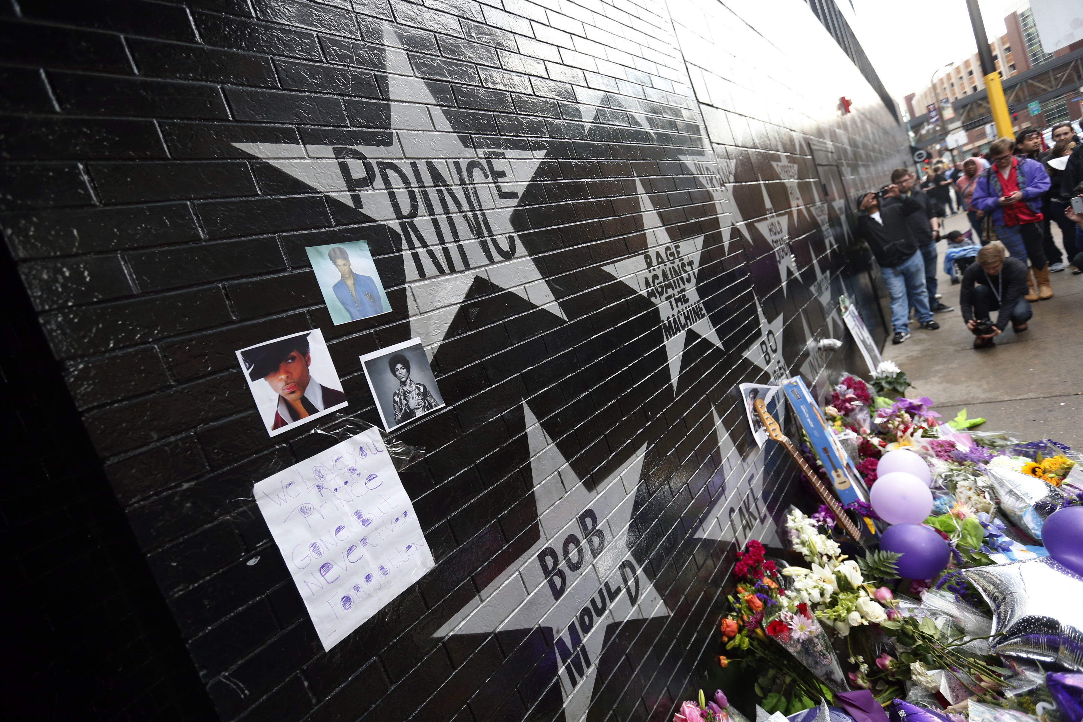 A memorial formed beneath Prince's star on the wall of First Avenue from www.citypages.com